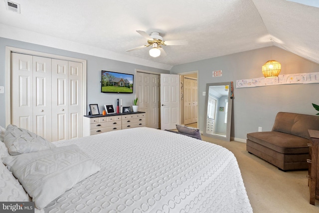 bedroom featuring two closets, light carpet, vaulted ceiling, baseboards, and ceiling fan