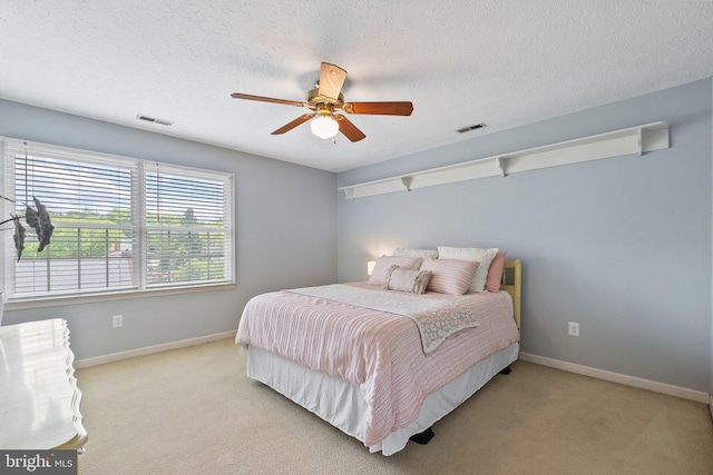 bedroom with carpet flooring, baseboards, a ceiling fan, and a textured ceiling