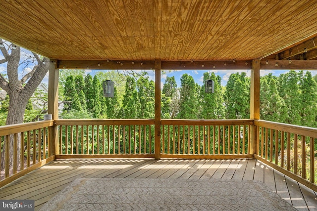 wooden deck with view of wooded area