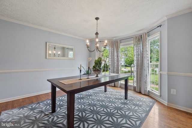 home office featuring a chandelier, crown molding, wood finished floors, a textured ceiling, and baseboards
