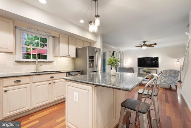 5731 Wooden Spoon Ct, Burke, VA 22015 - kitchen featuring stainless steel fridge, a sink, light wood-style floors, a kitchen bar, and crown molding