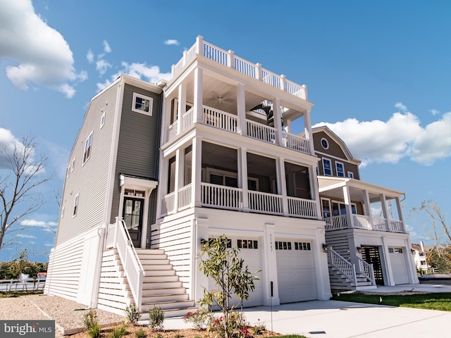 31447 Watershed Ln Unit 2, Bethany Beach, DE 19930 - raised beach house featuring stairway, a balcony, an attached garage, driveway, and a ceiling fan
