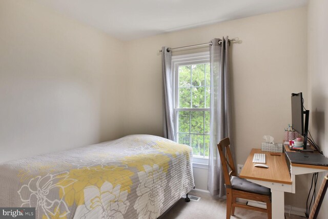 bedroom featuring light carpet and baseboards