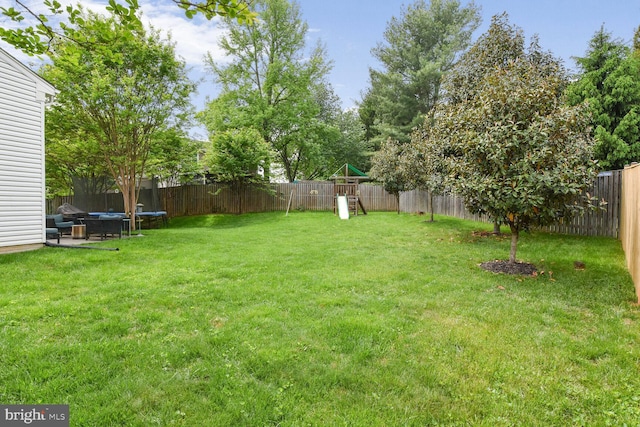 view of yard featuring a playground and a trampoline