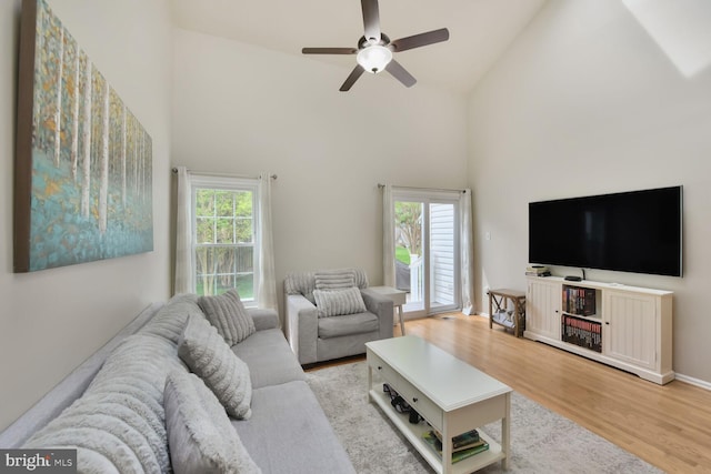 living room featuring high vaulted ceiling, ceiling fan, and wood finished floors