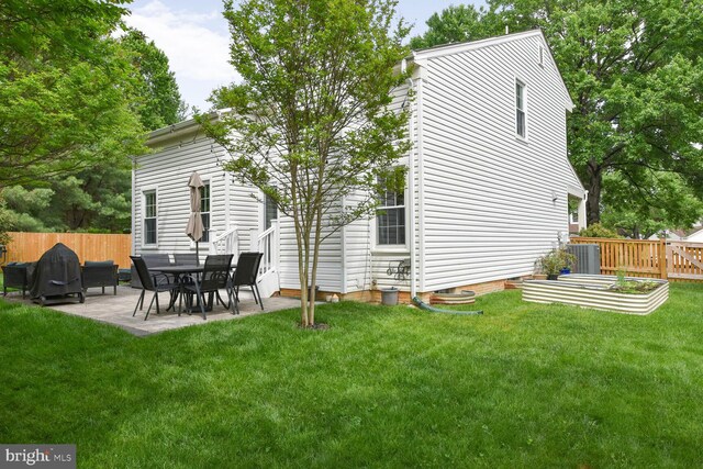 back of house with central air condition unit, a patio area, and a vegetable garden