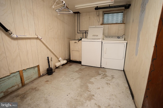 washroom with separate washer and dryer and wood walls