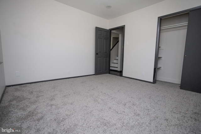 unfurnished bedroom with carpet flooring, baseboards, and a closet