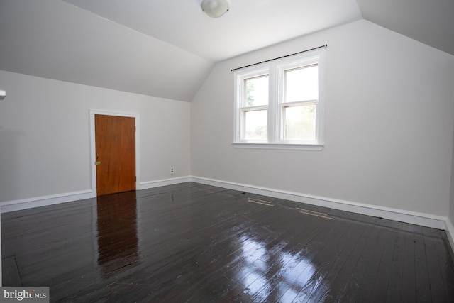 bonus room with vaulted ceiling, wood-type flooring, and baseboards