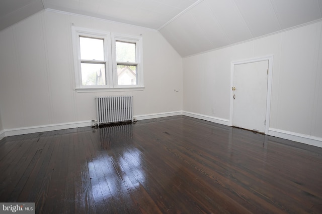 additional living space featuring radiator heating unit, hardwood / wood-style floors, vaulted ceiling, and baseboards