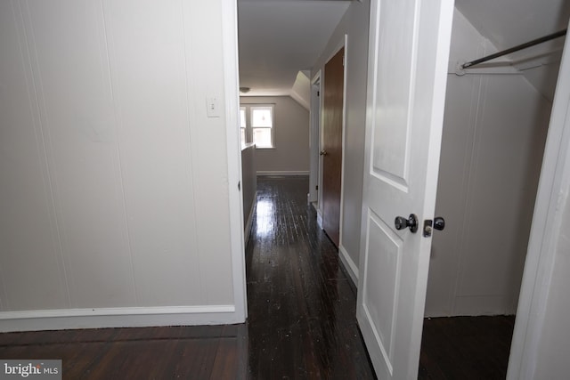 hallway with dark wood-style flooring and baseboards