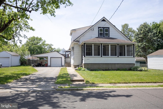 view of front facade featuring an outbuilding, asphalt driveway, a detached garage, roof with shingles, and a sunroom