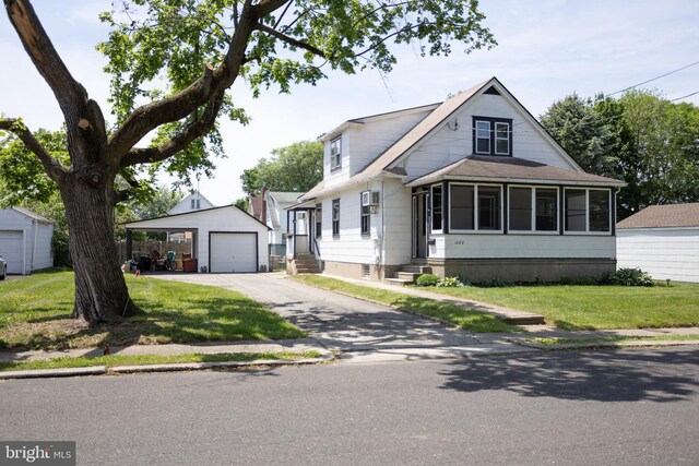 view of front of home with an outbuilding, driveway, a garage, entry steps, and a front yard