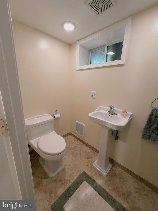 bathroom featuring toilet, tile patterned flooring, and baseboards