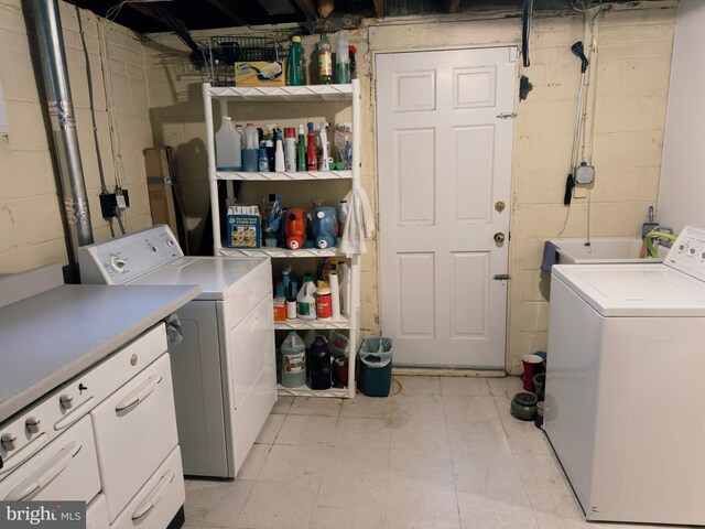 laundry area with cabinet space, concrete block wall, independent washer and dryer, and light floors