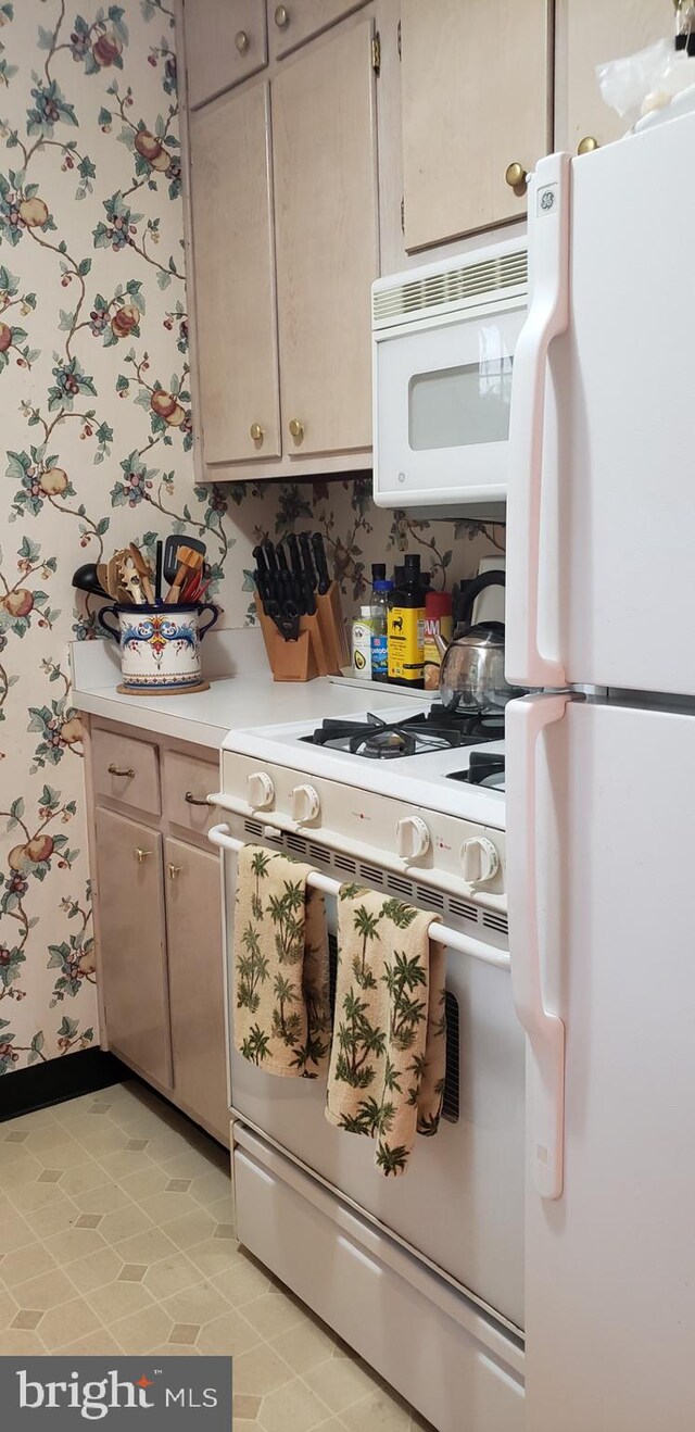 kitchen featuring white appliances, wallpapered walls, light countertops, baseboards, and light tile patterned flooring