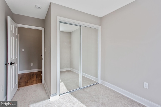 unfurnished bedroom featuring a closet, carpet, and baseboards