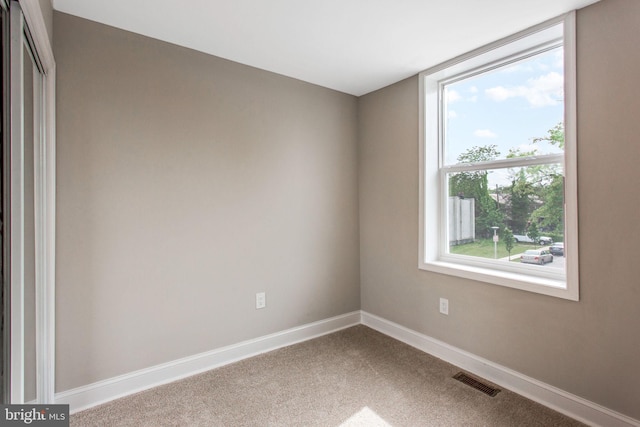 carpeted empty room featuring baseboards