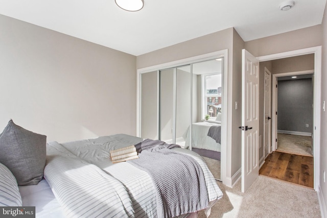 bedroom with a closet, carpet, and baseboards