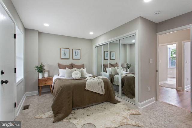 carpeted bedroom with a closet, baseboards, and recessed lighting