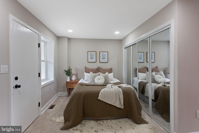 bedroom with light colored carpet, a closet, recessed lighting, and baseboards