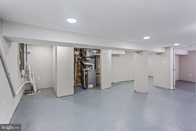 finished basement featuring heating unit and recessed lighting