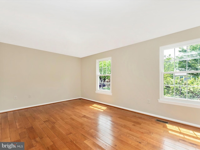 spare room featuring light wood finished floors and baseboards