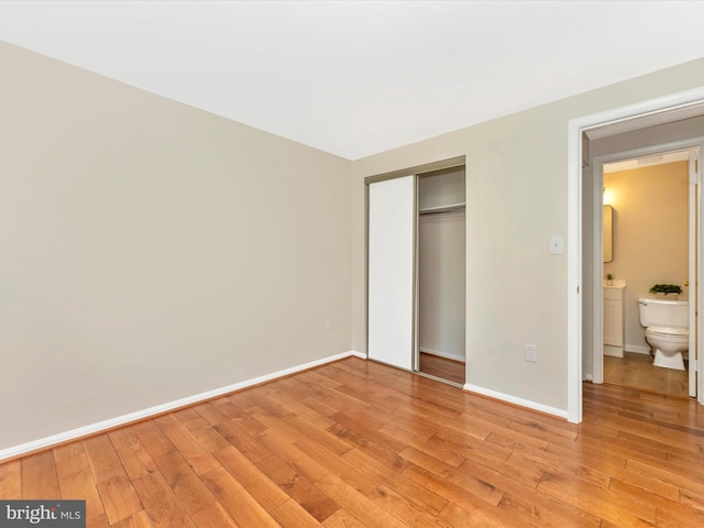 unfurnished bedroom featuring light wood-style floors, a closet, and baseboards