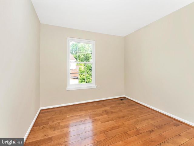 empty room featuring hardwood / wood-style flooring and baseboards
