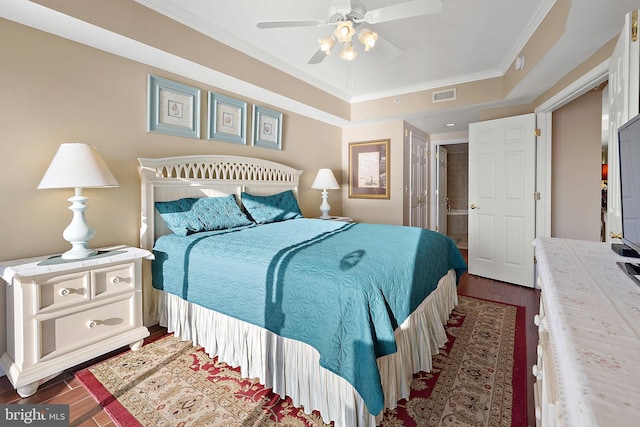 bedroom featuring dark wood finished floors, a raised ceiling, ornamental molding, and a ceiling fan