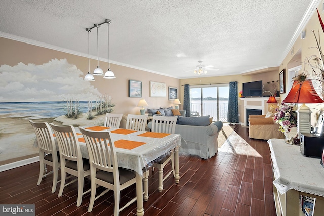 dining room featuring a textured ceiling, dark wood-type flooring, ornamental molding, ceiling fan, and baseboards