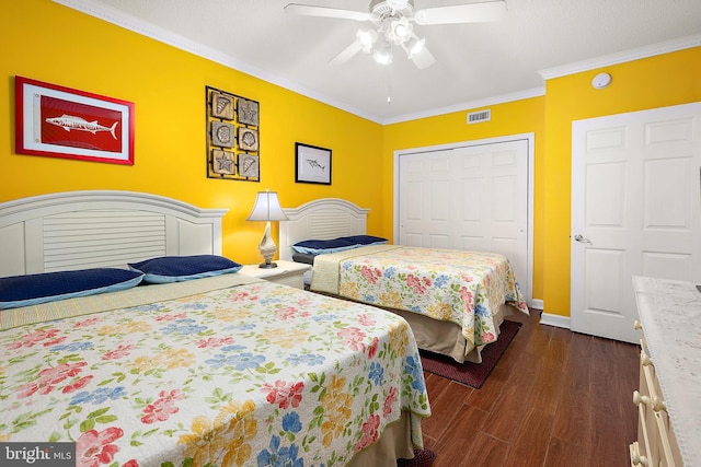 bedroom featuring a closet, dark wood-style floors, crown molding, baseboards, and a ceiling fan
