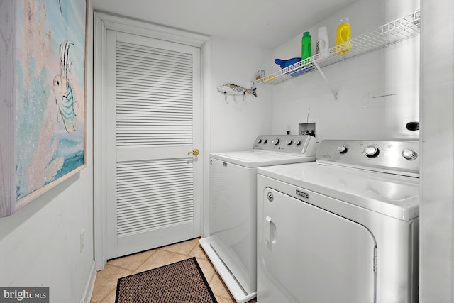 washroom featuring washer and clothes dryer and light tile patterned floors