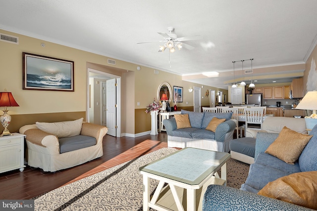 living area featuring ornamental molding, wood finished floors, ceiling fan, and baseboards