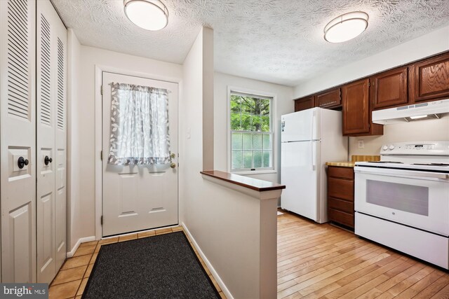 1279 Elm Grove Cir, Silver Spring, MD 20905 - kitchen with white appliances, under cabinet range hood, baseboards, a textured ceiling, and a peninsula