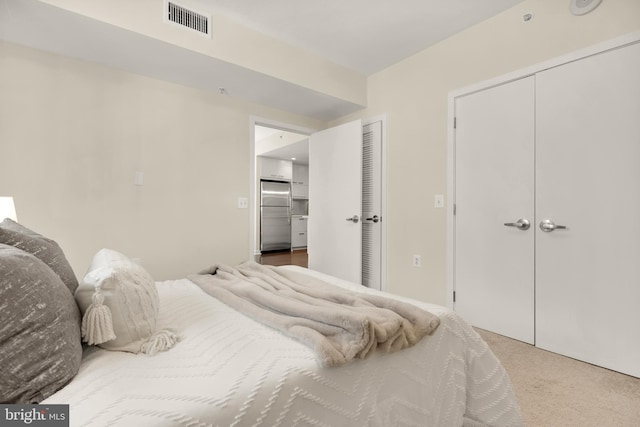 bedroom with stainless steel fridge and carpet floors