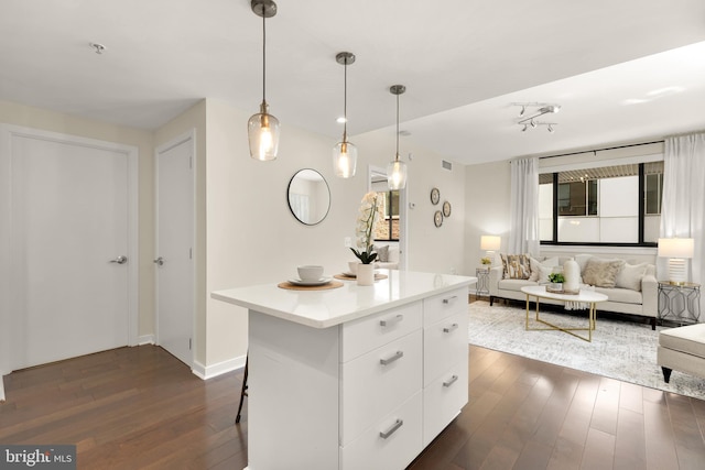 kitchen featuring dark wood-style floors, modern cabinets, white cabinetry, a center island, and light countertops
