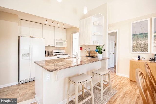 28 Diane Rd, Manahawkin, NJ 08050 - kitchen featuring white appliances, a sink, open shelves, white cabinetry, and light stone counters