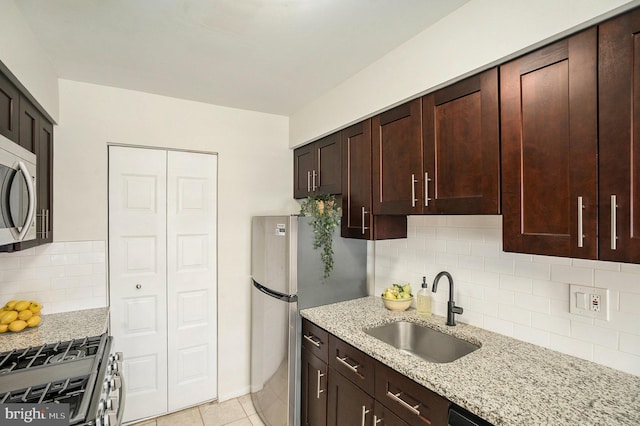 7015 Ridge Ave Unit 19, Philadelphia, PA 19128 - kitchen with a sink, stainless steel appliances, light stone counters, decorative backsplash, and dark brown cabinetry