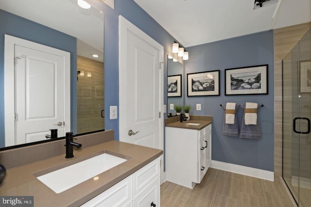 527 Seaway Ln, Cambridge, MD 21613 - bathroom featuring a stall shower, two vanities, and baseboards