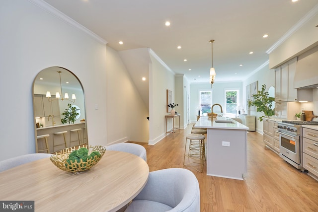 309 M St NW Unit B, Washington, DC 20001 - kitchen featuring stainless steel stove, a sink, a center island with sink, light wood-style floors, and crown molding