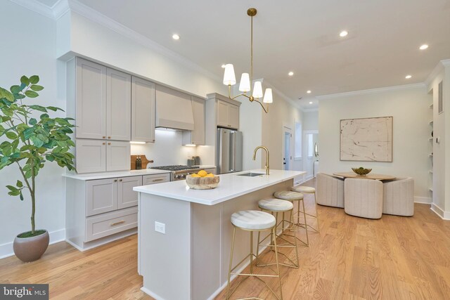 309 M St NW Unit B, Washington, DC 20001 - kitchen with a sink, gray cabinets, appliances with stainless steel finishes, a kitchen bar, and light wood-style flooring