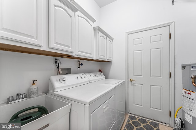clothes washing area with cabinet space, washer and dryer, and water heater