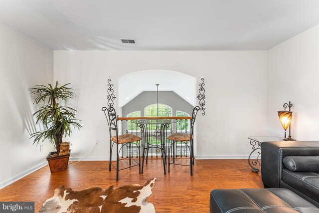 dining area featuring wood finished floors, vaulted ceiling, and baseboards
