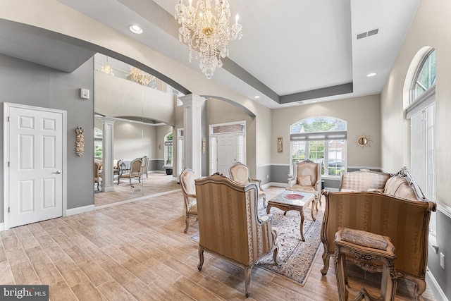 living room with arched walkways, ornate columns, recessed lighting, baseboards, and a chandelier