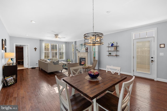 23325 April Mist Pl, Brambleton, VA 20148 - dining room with a glass covered fireplace, dark wood-style floors, baseboards, a ceiling fan, and recessed lighting