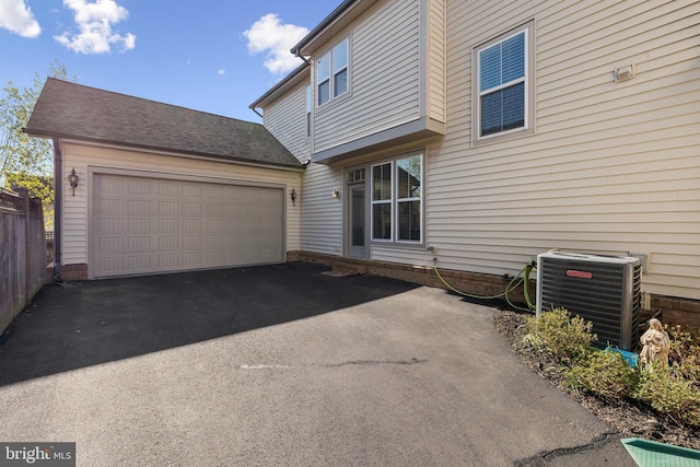 23325 April Mist Pl, Brambleton, VA 20148 - view of side of home with central AC unit, asphalt driveway, and a garage