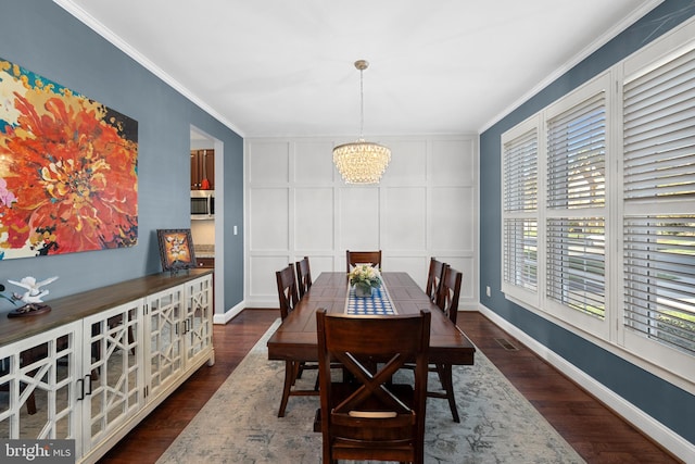 23325 April Mist Pl, Brambleton, VA 20148 - dining area featuring a decorative wall, a chandelier, crown molding, dark wood-style floors, and baseboards