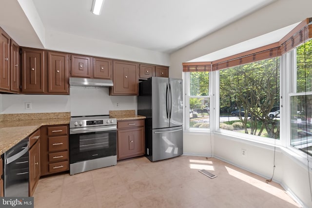 11543 Summer Oak Dr, Germantown, MD 20874 - kitchen with appliances with stainless steel finishes, plenty of natural light, under cabinet range hood, and light stone countertops