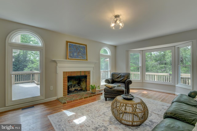 living area with wood finished floors, baseboards, and a fireplace